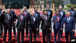 Chinese President Xi Jinping, front row third right, waves with leaders attending the Belt and Road Forum as they pose for a group photo at the Yanqi Lake venue on the outskirt of Beijing, China, Monday, May 15, 2017. They are, front row from left, Turkish President Recep Tayyip Erdogan, Vietnamese President Tran Dai Quang, Russian President Vladimir Putin, Xi, Indonesian President Joko "Jokowi" Widodo and Kazakhstan President Nursultan Nazarbayev, and second row from third left to right, Hungarian Prime Minister Viktor Orban, Cambodian Prime Minister Hun Sen, Spanish Prime Minister Mariano Rajoy, Malaysian Prime Minister Najib Razak and Ethiopian Prime Minister Hailemariam Desalegn. (AP Photo/Ng Han Guan, Pool)