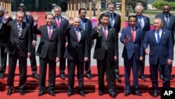 Chinese President Xi Jinping, front row third right, waves with leaders attending the Belt and Road Forum as they pose for a group photo at the Yanqi Lake venue on the outskirt of Beijing, China, Monday, May 15, 2017. They are, front row from left, Turkis