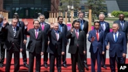 Chinese President Xi Jinping, front row third right, waves with leaders attending the Belt and Road Forum as they pose for a group photo at the Yanqi Lake venue on the outskirt of Beijing, China, Monday, May 15, 2017. They are, front row from left, Turkish President Recep Tayyip Erdogan, Vietnamese President Tran Dai Quang, Russian President Vladimir Putin, Xi, Indonesian President Joko "Jokowi" Widodo and Kazakhstan President Nursultan Nazarbayev, and second row from third left to right, Hungarian Prime Minister Viktor Orban, Cambodian Prime Minister Hun Sen, Spanish Prime Minister Mariano Rajoy, Malaysian Prime Minister Najib Razak and Ethiopian Prime Minister Hailemariam Desalegn. (AP Photo/Ng Han Guan, Pool)