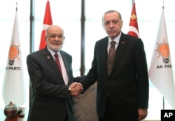 FILE - Turkey's President Recep Tayyip Erdogan, right, shakes hands with Temel Karamollaoglu, the leader of pro-Islamic Felicity Party, before their talks in Ankara, Turkey, Feb. 9, 2018.