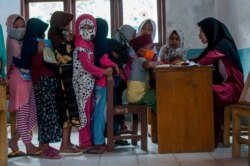 Anak-anak memakai masker pelindung berbaris saat kegiatan belajar mengajar di tengah wabah COVID-19 di Lebak, Provinsi Banten, 4 Agustus 2020. (Foto: Antara/Muhammad Bagus Khoirunas/via Reuters)