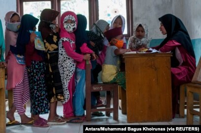 Anak-anak memakai masker pelindung berbaris saat kegiatan belajar mengajar di tengah wabah COVID-19 di Lebak, Provinsi Banten, 4 Agustus 2020. (Foto: Antara/Muhammad Bagus Khoirunas/via Reuters)