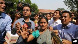 Wartawan berkerumun di sekitar Asha Devi, ibu dari korban pemerkosaan geng brutal pada bus yang bergerak, setelah putusan Mahkamah Agung dalam kasus tersebut, di New Delhi, India, 5 Mei 2017.(AP Photo/Altaf Qadri).