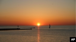 FILE - A sunset is shown on Lake Ontario in Niagara County. An American-built, Canadian-owned sloop that sank in Lake Ontario more than 200 years ago has been found by a team of underwater explorers.