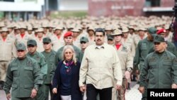 Nicolás Maduro camina junto a su esposa Cilia Flores, el ministro de Defensa de Venezuela, Vladimir Padrino López, y Remigio Ceballos, comandante estratégico de operaciones de las Fuerzas Armadas, durante una ceremonia con miembros de la milicia venezolana en Caracas, Venezuela, 27 de julio de 2019. Palacio de Miraflores / vía REUTERS.