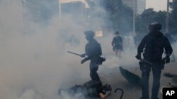 La policía lanza gas lacrimógeno a manifestantes en Hong Kong, el domingo 29 de septiembre de 2019,