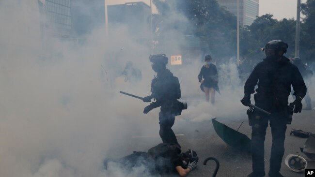 La policía lanza gas lacrimógeno a manifestantes en Hong Kong, el domingo 29 de septiembre de 2019,