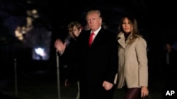 Presiden Amerika Serikat Donald Trump bersama Ibu Negara AS Melania Trump dan putra mereka Barron Trump, melambaikan tangan setibanya di Gedung Putih, Washington DC, 1 Januari 2017, sekembalinya dari liburan akhir tahun di Mar-a-Lago estate, Palm Beach, Florida.