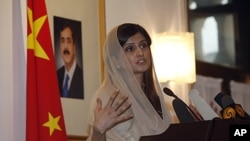 Pakistan's Foreign Minister Hina Rabbani Khar speaks near a portrait of Pakistan's Prime Minister Yusuf Raza Gilani at the Pakistan Embassy in Beijing, China, August 24, 2011