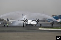 In this photo provided by Tasnim News Agency, a traditional water cannon salute welcomes an Iran Air's new commercial aircraft at Mehrabad airport in Tehran, Iran, Aug. 5, 2018.