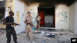 Libyan military guards check one of the U.S. Consulate's burnt out buildings during a visit by Libyan President Mohammed el-Megarif, not shown, to the U.S. Consulate, Sept 14, 2012.