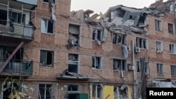 Rescuers work at a site of an apartment building damaged by a Russian military strike in Mykolaiv October 13, 2022. 