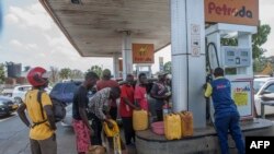 ARQUIVO: Pessoas fazem fila com bidões para comprar combustível na estação de serviço Biwi Triangle Petroda em Lilongwe, no Malawi, a 1 de outubro de 2021.