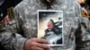 Seorang demonstran memegang foto Qassem Soleimani dalam aksi protes menentang serangan udara AS yang menewaskan Mayor Jenderal Iran Qassem Soleimani, kepala Pasukan elit Quds, dan komandan milisi Irak Abu Mahdi al-Muhandis, 2 Januari 2019. 