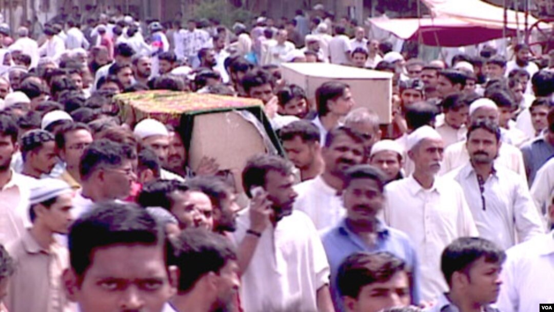 Warga Pakistan memakamkan para korban tewas akibat kekerasan politik dan etnis di Karachi (19/8).