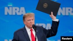 Президент США тримає папку з наказом про вихід США з угоди ООН стосовно торгівлі зброєю