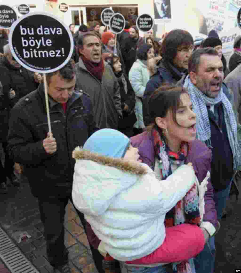 Hundreds of people hold placards that read 'This case won't end this way' outside a courthouse in Istanbul, Turkey, Tuesday, Jan. 17, 2012. A prosecutor is demanding life imprisonment for seven men accused of involvement in the killing of an ethnic Armen