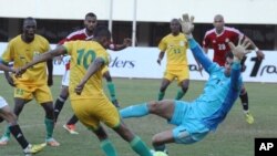 Le joueur zimbabwéen Obvious Karuru, à gauche, décoche un tir que le gardien égyptien Ahmed Ekram tente de repousser lors d’un match de qualification de Coupe du Monde entre le Zimbabwe et l'Egypte au Stade national des sports à Harare, dimanche 9 juin 2013.