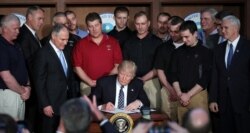 FILE - U.S. President Donald Trump signs an executive order eliminating Obama-era climate change regulations at the Environmental Protection Agency in Washington, March 28, 2017.