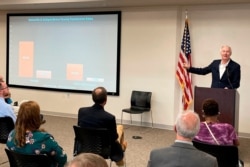 Arkansas Governor Asa Hutchinson shows a chart on vaccination rates at a town hall meeting in Batesville, July 12, 2021.