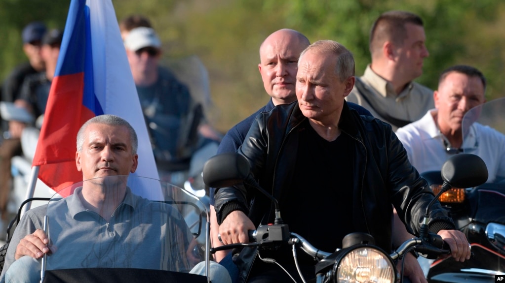 Russian President Vladimir Putin drives a motorbike during the Babylon's Shadow bike show camp near in Sevastopol, Crimea, Saturday, Aug. 10, 2019. Head of the Republic of Crimea Sergei Aksenov, is in sidecar, and acting Governor of Sevastopol…