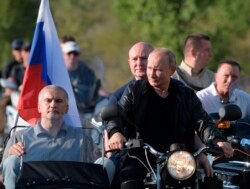 FILE - Russian President Vladimir Putin drives a motorbike during the Babylon's Shadow bike show camp near in Sevastopol, Crimea, Aug. 10, 2019.