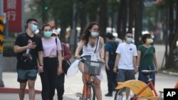 People wear face masks to protect against the coronavirus after authorities raised the COVID-19 alert to level 3 in Taipei, Taiwan, May 15, 2021. 