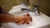 FILE - A man washes his hands at a shopping mall in Ciudad Juarez, Mexico, March 22, 2019. 