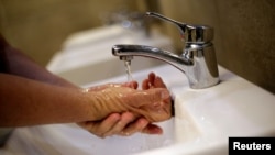 FILE - A man washes his hands at a shopping mall in Ciudad Juarez, Mexico, March 22, 2019. 