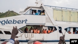 Moradores aplaudem do cais quando o ferry Englebert chega de Bukavu ao porto de Goma, a 18 de fevereiro de 2025.