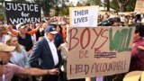 Anthony Albanese, Perdana Menteri Australia, mengenakan topi dan berdiri di dekat spanduk saat menghadiri pertemuan umum yang menyerukan langkah-langkah untuk mengakhiri kekerasan terhadap perempuan di Canberra pada Minggu, 28 April 2024. (Foto: via AP)