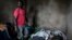 A health worker works to clean and dress the bodies of a young boy and man, who were killed the night before, allegedly by rebels from the Allied Democratic Forces, Oct. 5, 2018, in Beni, Democratic Republic of the Congo.
