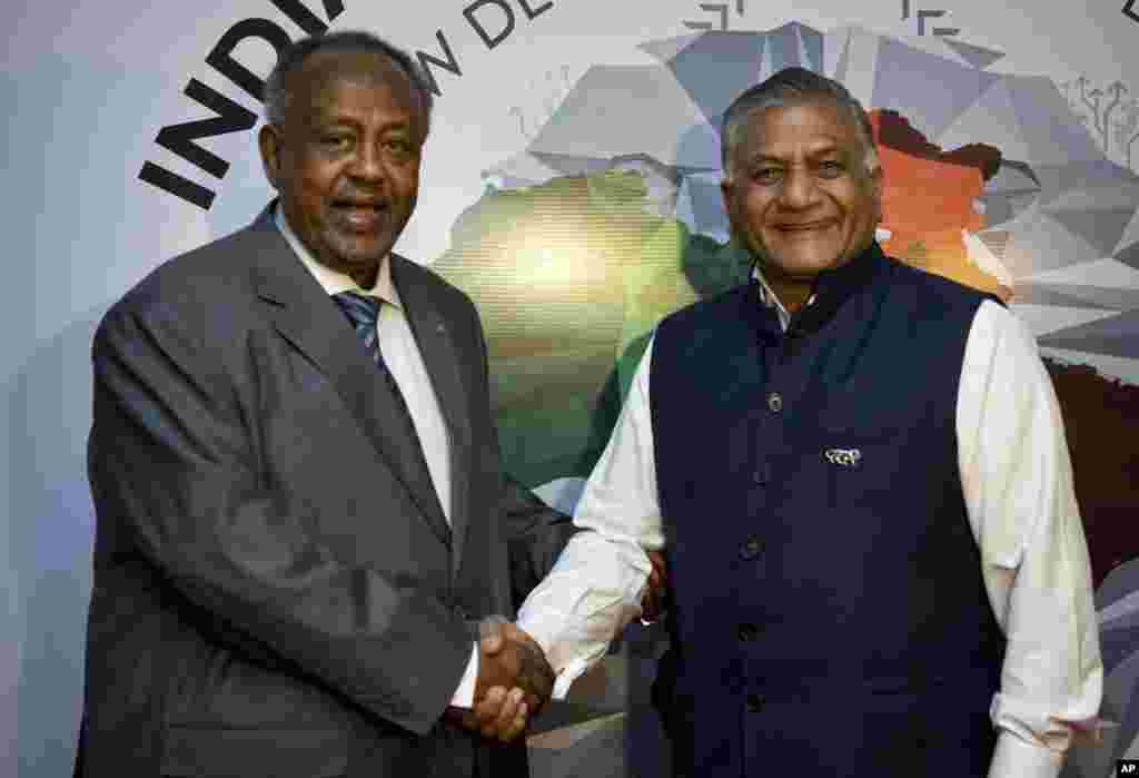 Shugaba Ismail Omar Guelleh, na Djibouti, hagu, yana gaisawa da mai tarbarsa, karamin ministan harkokin wajen Indiya, Vijay Kumar Singh,lokacin da ya isa wurin taro