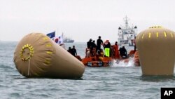 Pemimpin oposisi Myanmar Aung San Suu Kyi (tengah) meninggalkan sebuah vihara dengan perahu setelah mengunjungi korban banjir yang ditampung di Bago, 80 kilometer Yangon timur laut, Myanmar, 3 Agustus 2015.