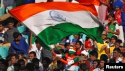 FILE - A fan waves an Indian flag during a cricket match against England, Nov. 19 ,2016. Amazon pulled doormats depicting the Indian flag.