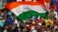 FILE - A fan waves an Indian flag during a cricket match against England, Nov. 19 ,2016. Amazon pulled doormats depicting the Indian flag.