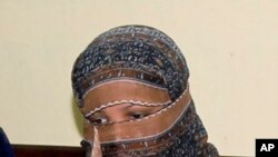 Pakistani Christian woman Asia Bibi, listens to Governor of Pakistani Punjab Province Salman Taseer, unseen, at a prison in Sheikhupura near Lahore, Nov. 20, 2010. 