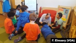 Students at Mundo Verde bi-lingual school work on solving a mystery with teacher David Levin.