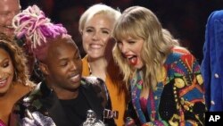 Taylor Swift (derecha) acepta el premio a mejor video del año por "You Need to Calm Down" en los premios MTV el lunes, 26 de agosto, de 2019, en el Prudential Center en Newark, Nueva Jersey, EE.UU.