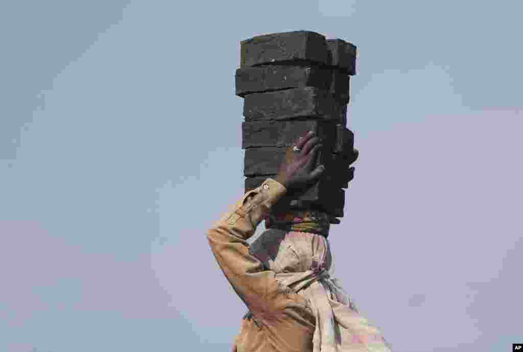 A woman carries bricks at a brick kiln on the outskirts of Hyderabad, India.