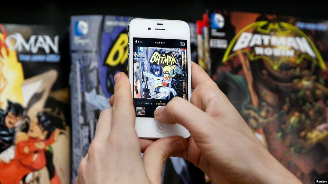 Seorang penggemar mengambil foto buku komik Batman dalam perayaan Hari Batman di sebuah toko komik di New York (23/7). (Reuters/Shannon Stapleton)