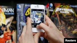Seorang penggemar mengambil foto buku komik Batman dalam perayaan Hari Batman di sebuah toko komik di New York (23/7). (Reuters/Shannon Stapleton)