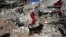 A rescue worker searches the debris with his sniffing dog on the earthquake site in Sarpol-e-Zahab in western Iran, Nov. 14, 2017. 