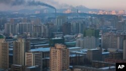 Smoke rises from factories over central Pyongyang, North Korea, Dec. 9, 2011. (AP)