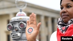 FILE - An activist from the Campaign to Stop Killer Robots, a coalition of non-governmental organizations opposing lethal autonomous weapons or so-called 'killer robots', protests at Brandenburg Gate in Berlin, Germany, March, 21, 2019. 