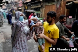 A health worker gives a polio vaccine to a child in a downtown area of Lahore, Pakistan, Monday, Sept. 9, 2024. (AP Photo/K.M. Chaudary)