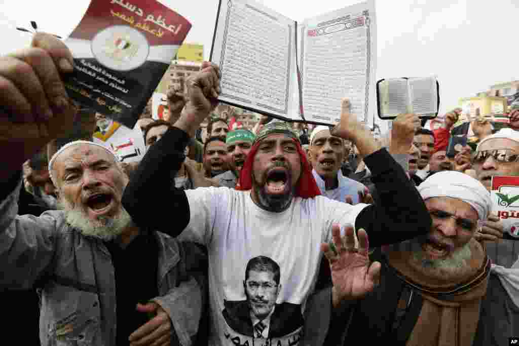 Supporters of Egyptian President Mohammed Morsi chant slogans as one holds up the Quran, Islam's holy book, during a demonstration after the Friday prayer, in Cairo, Egypt, Friday, Dec. 14.