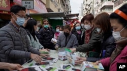 People buy face masks from a street vendor in Hong Kong, Saturday, Feb, 1, 2020.