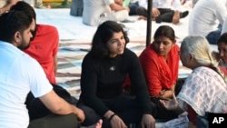 Sakshi Malik, center, an Indian wrestler who won a bronze medal at the 2016 Summer Olympics, speaks with social activist Medha Patkar, right, during a protest against Wrestling Federation of India President Brij Bhushan Sharan Singh and other officials in New Delhi, India, April 28, 2023.