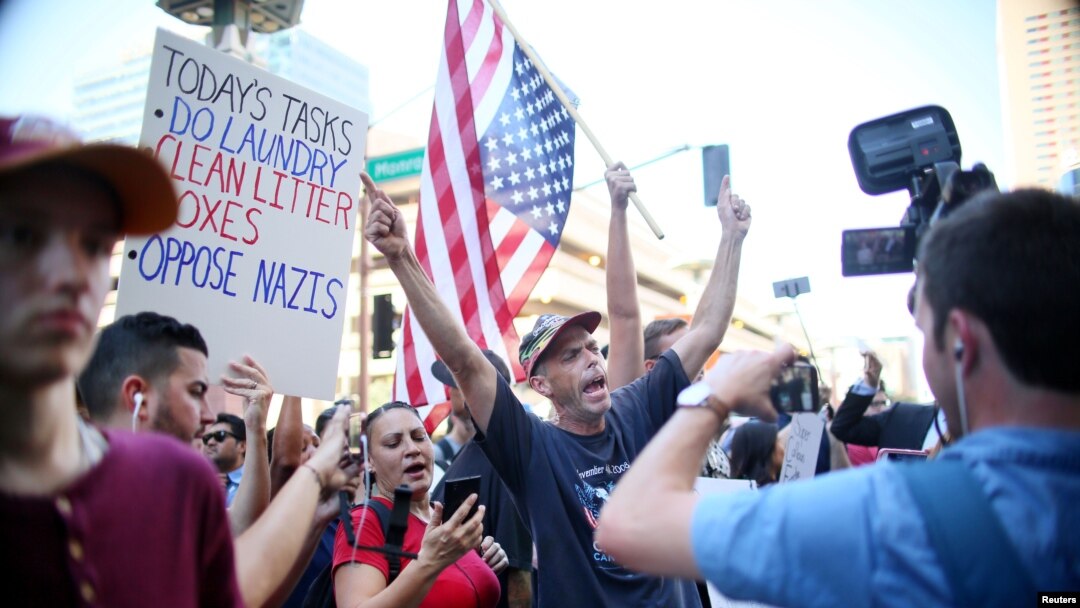 Pro Trump supporters face off with peace activists during protests outside a Donald Trump campaign rally in Phoenix, Ariz., Aug. 22, 2017.